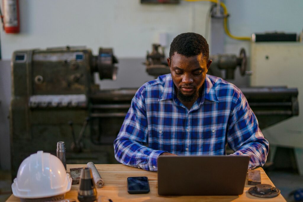 Blue collar worker is working at machine shop.
