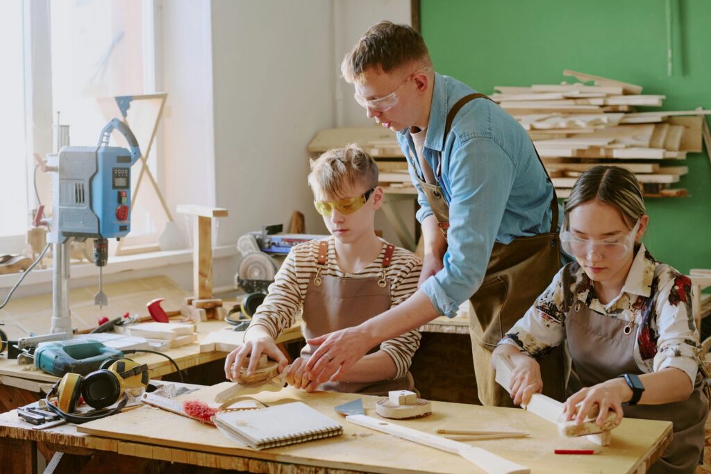 Teenagers Learning Woodworking with Instructor in Vocational Class